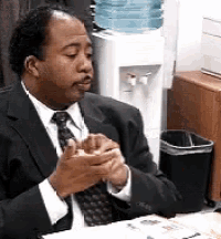 a man in a suit and tie is eating a sandwich