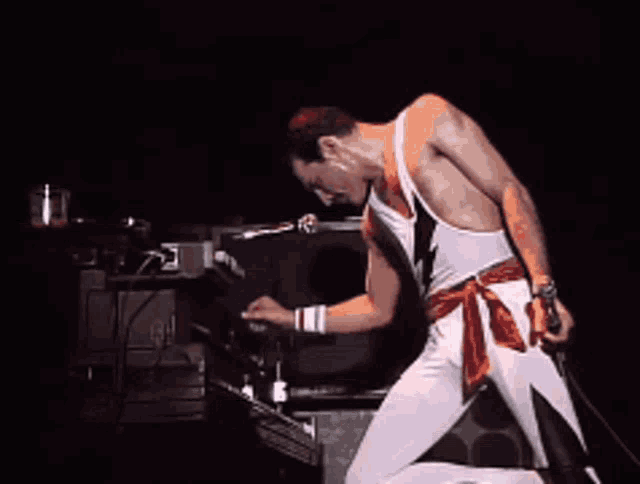 a man with a lightning bolt on his outfit is dancing on stage