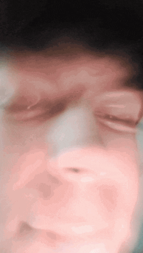 a close up of a person 's face with a blurred background