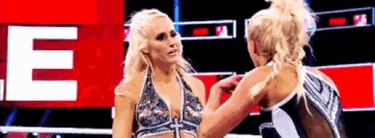 a couple of women are standing next to each other in a boxing ring .