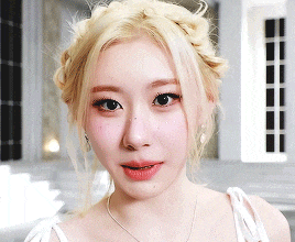 a close up of a woman 's face with blonde hair and a braid
