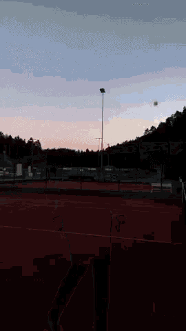 a man is running on a track with a tennis ball in his hand