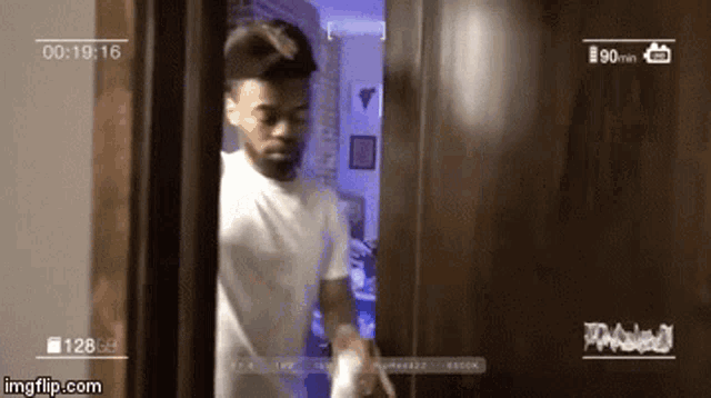 a man in a white shirt is standing in a room with a watermark that says imgflip.com on the bottom