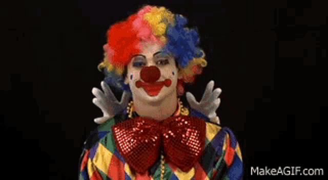 a man dressed as a clown is making a funny face with his hand on his head .