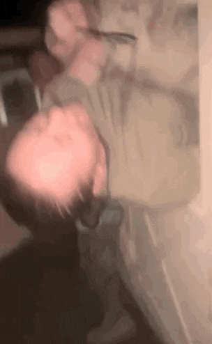 a blurry picture of a man holding a knife to his face .