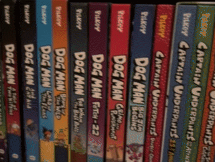 a row of dog man books are lined up on a bookshelf