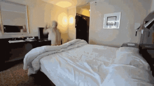 a hotel room with a large bed and a basketball hoop on the wall