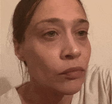 a close up of a woman 's face with a tear coming out of her nose