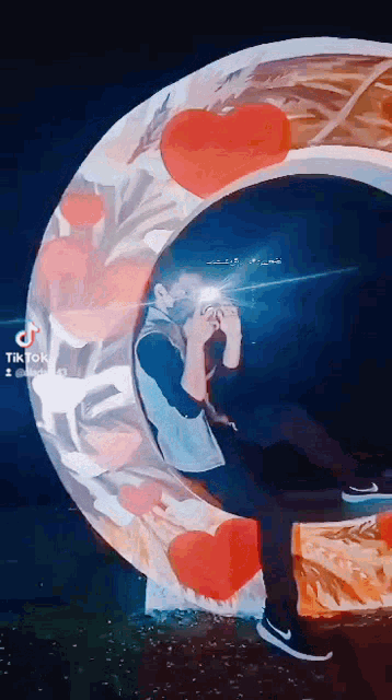 a man is taking a picture of himself in a circle with red hearts