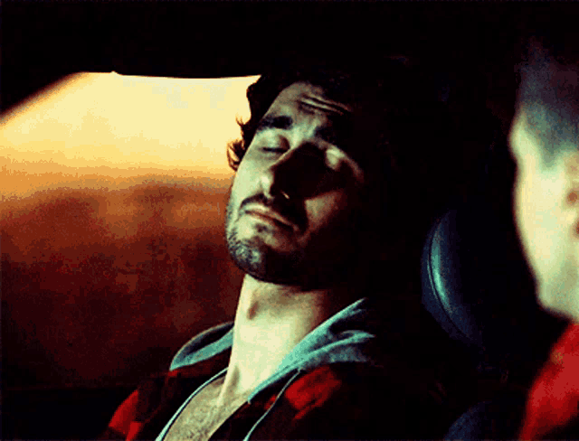 a man with his eyes closed is sitting in a car