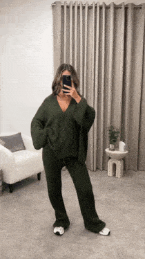 a woman is taking a picture of herself in a room