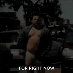a shirtless man in a suit and underwear is standing in front of a parking lot .