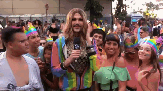 a man in a wig holds a microphone in front of a crowd