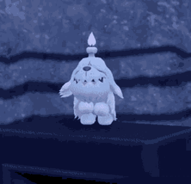 a stuffed animal with a candle on its head