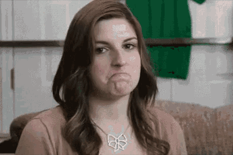 a woman wearing a bow necklace makes a face