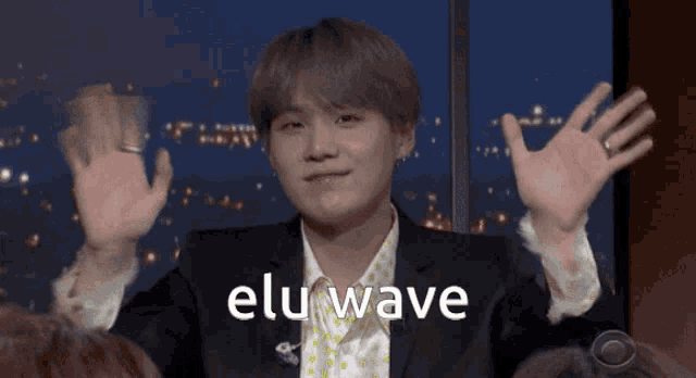 a man in a suit with the word elu wave written on his chest