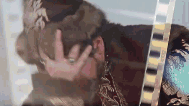 a man with a crown on his head covering his face with his hand