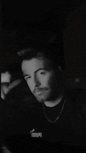 a black and white photo of a man 's face with a beard