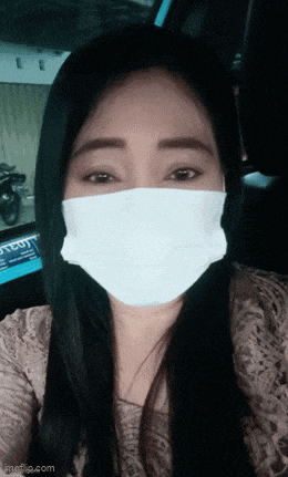 a woman wearing a face mask is sitting in a car with a license plate that says tc01