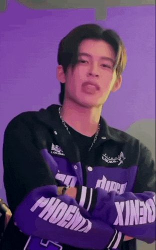 a young man wearing a purple jacket and boxing gloves is making a funny face .