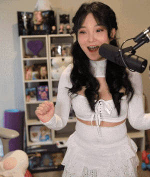 a woman is singing into a microphone in a room