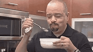 a man is eating a bowl of cereal with a spoon .