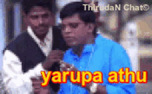 a man in a blue shirt is standing next to another man with the word yarupa athu in red