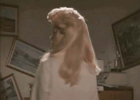 a woman with blonde hair is standing in a room .