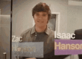 a man is standing in front of a glass wall with the names isaac and hansen on it