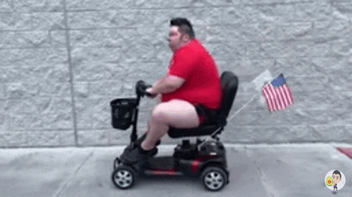 a fat man is riding a mobility scooter with an american flag attached to the back .
