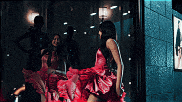a woman in a red dress is looking at herself in a mirror