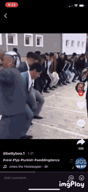a group of men are dancing in a line on a cell phone screen