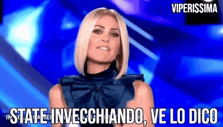 a woman in a blue top says " state invecchiando ve lo digo "