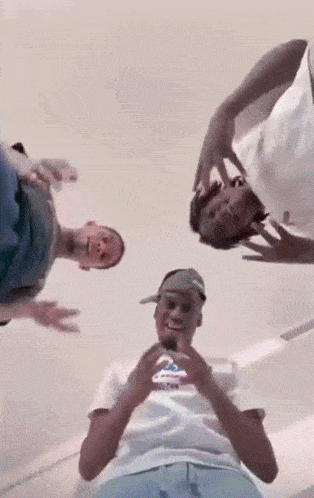 a group of young men are standing next to each other in a room looking up at the camera .