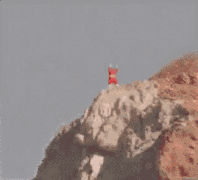 a man in a red superhero costume with a big belly is holding his belly .