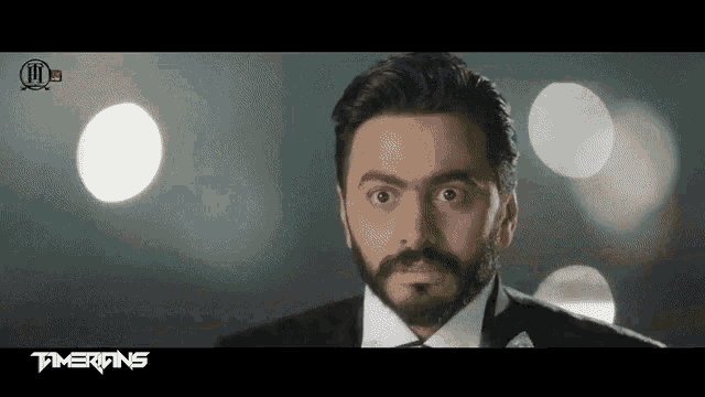 a man with a beard is wearing a tuxedo and bow tie .