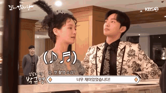 a man and a woman standing next to each other with a kbs logo on the bottom right