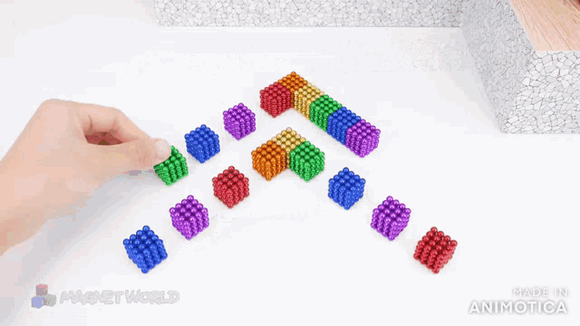 a person is holding a bunch of colorful magnet beads