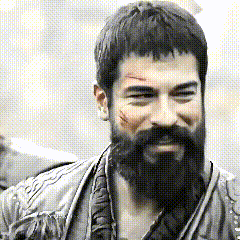 a man with a beard and a scar on his face is smiling