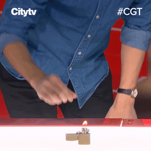 a man in a denim shirt is lighting a lighter with a citytv logo in the background