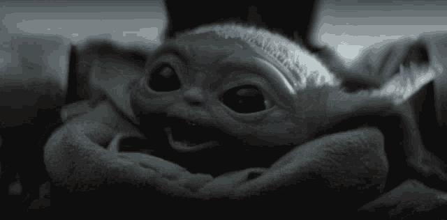 a black and white photo of a baby yoda with its mouth open