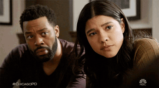 a man and a woman are sitting next to each other with a chicagopd logo in the background