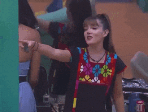 a woman in a colorful shirt points to a hot dog can