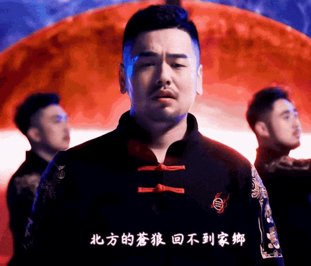 a man wearing a black jacket with chinese writing on the front