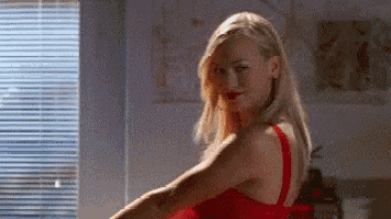 a woman in a red dress is dancing in a room .