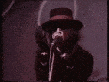 a man in a top hat singing into a microphone