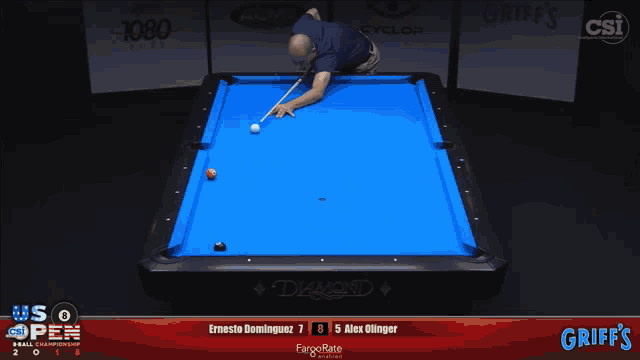 a pool table with a blue cloth and a man holding a cue