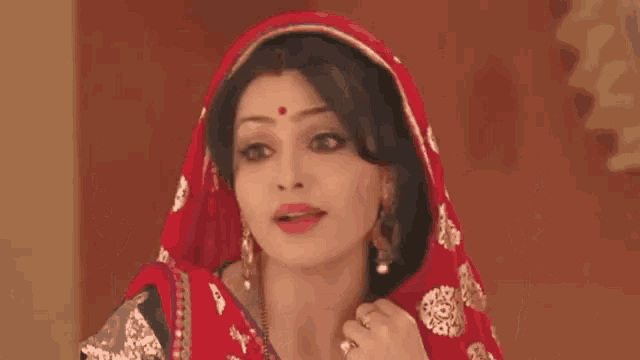 a close up of a woman 's face with a red bindi