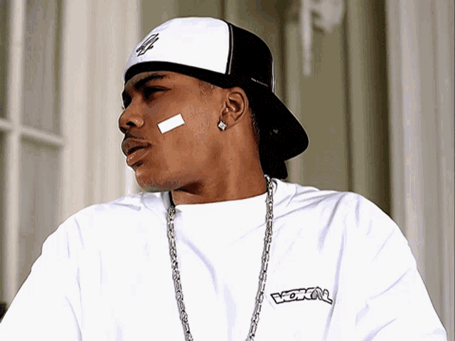 a man wearing a black and white hat and a white shirt with the word vox on the front