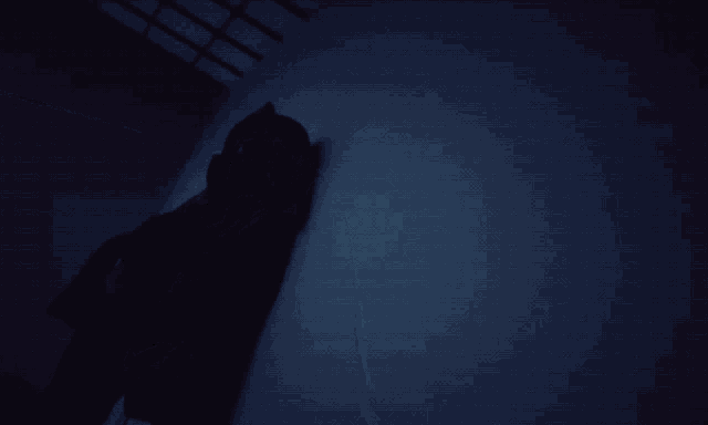 a person in a hooded jacket leaning against a wall